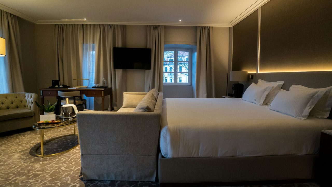 Luxury hotel guest room with king bed and TV